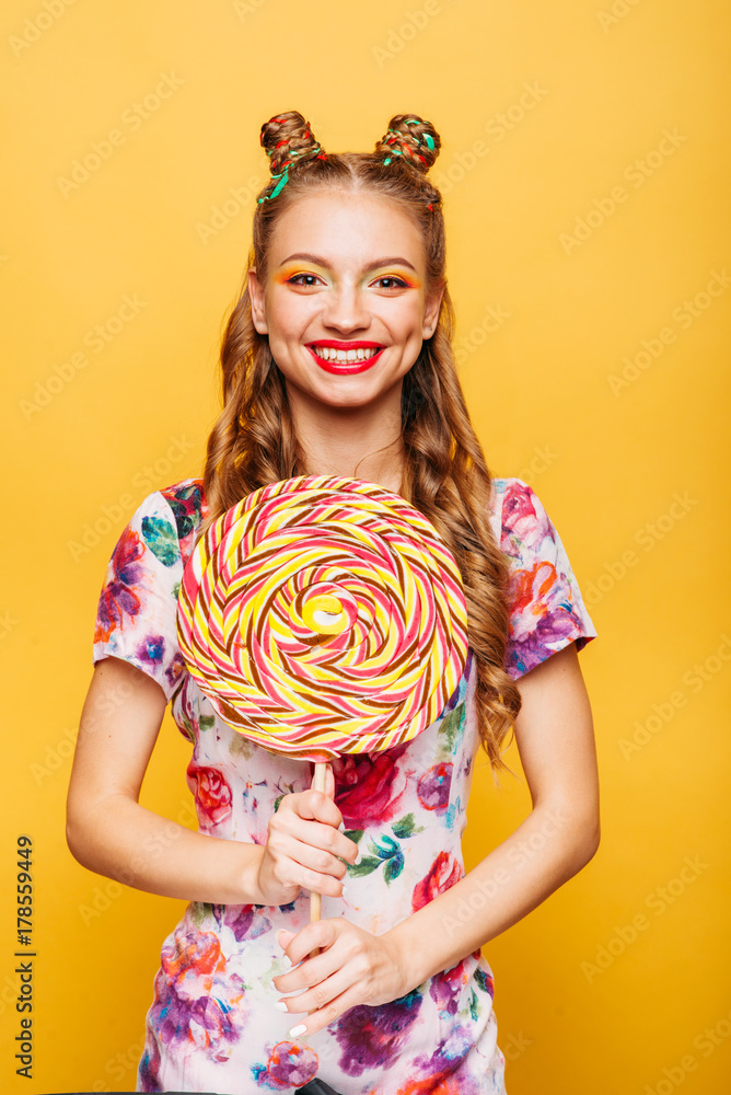 Funny teenage girl holdss big lollipop