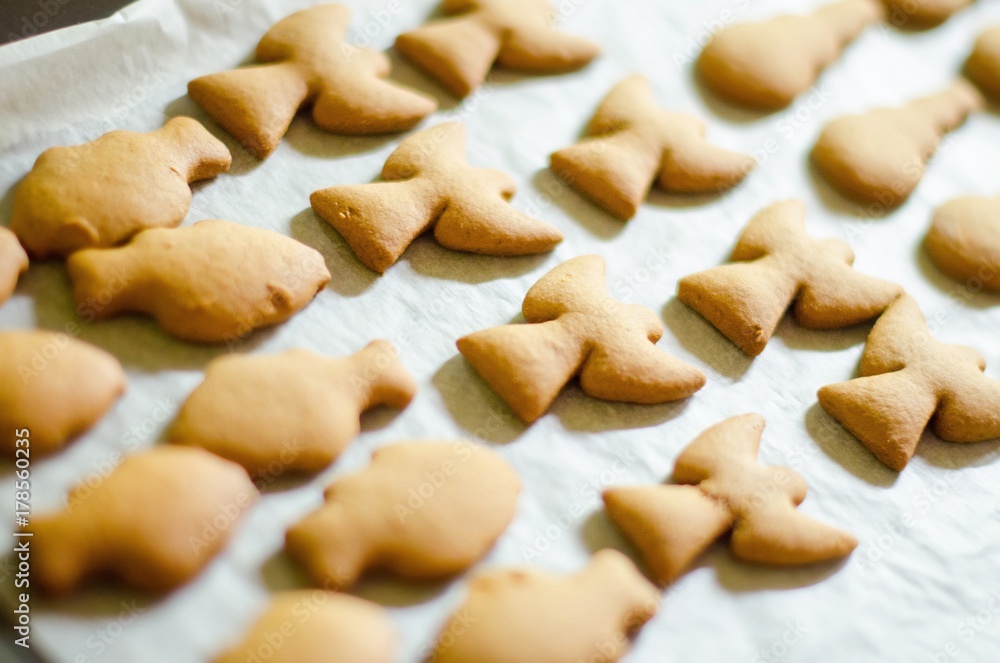 Set of Christmas theme shaped cookies on white cooking paper background. Ange, snowman and fish Set of Christmas theme shaped cookies on white cooking paper background. Ange, snowman and fish