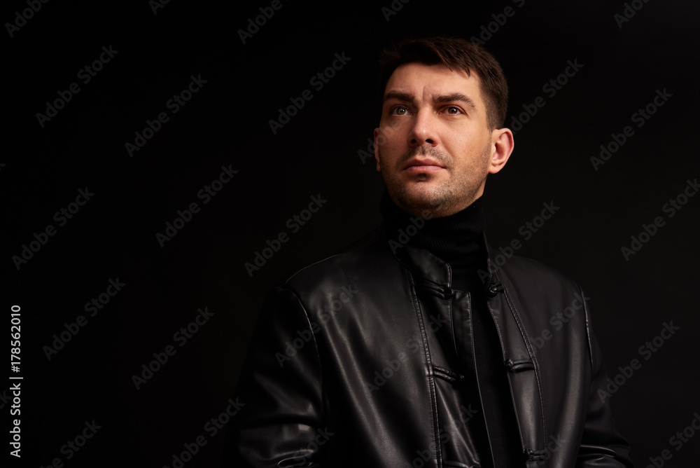 confident handsome man looking away. Black background