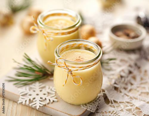 Eggnog alcoholic beverage served with cinnamon or nutmeg.  Traditional drink often served during Christmas photo