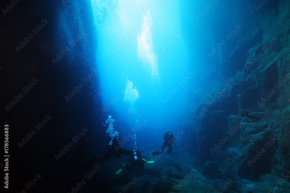 Obraz premium Underwater caves in the ocean with scuba divers