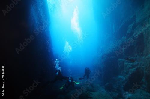 Underwater caves in the ocean with scuba divers photo