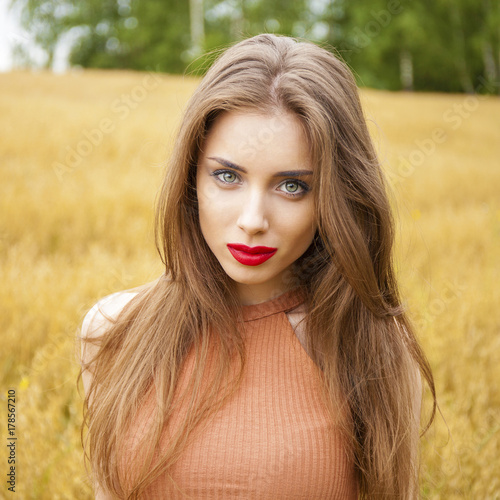 Young brunette woman in Oats field, summer outdoors