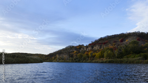 A river with autumn trees and beautiful clouds. Travels. Fishing
