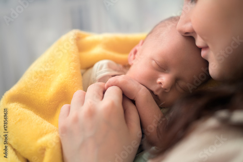 Beautiful woman holding a newborn baby in her arms,