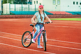 Teenage girl relaxing on a stadium.The girl way of life by bike.