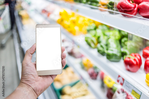 hand use smartphone with blur background of supermarket