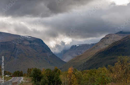 Norwegian mountain scenery with dramatic clouds and a lonely road