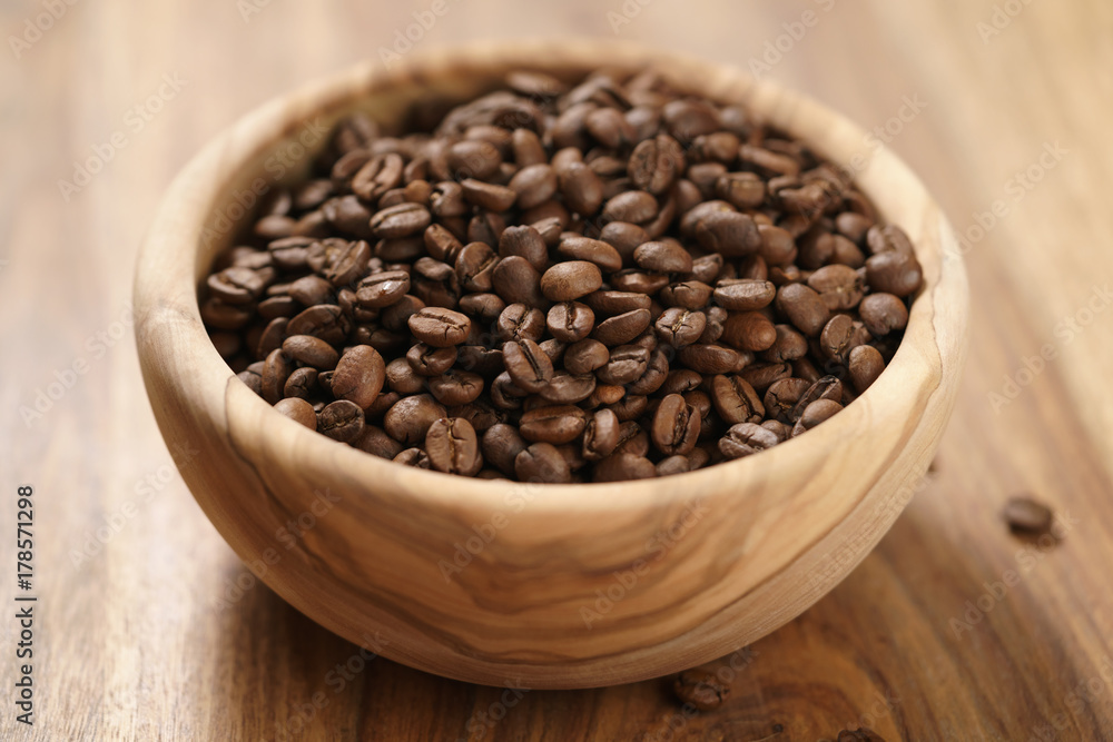 roasted coffee beans in wood bowl on table