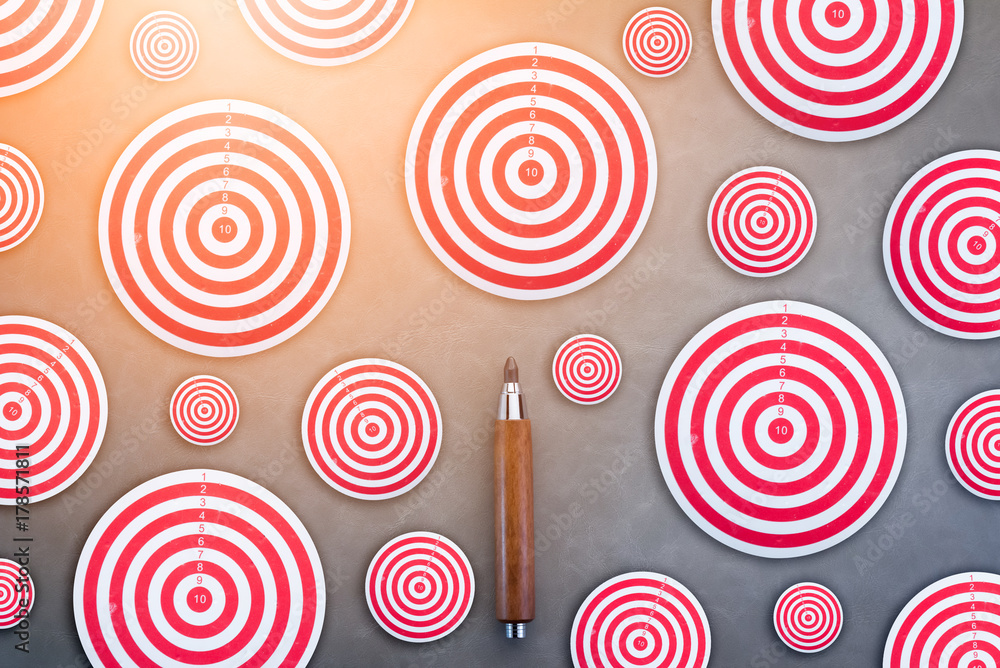 business target ideas concept with many size of dart board and wooden pencil on grey background business target ideas concept with many size of dart board and wooden pencil on grey background