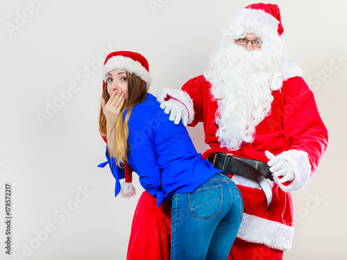 Santa Claus spanking woman with christmassy hat