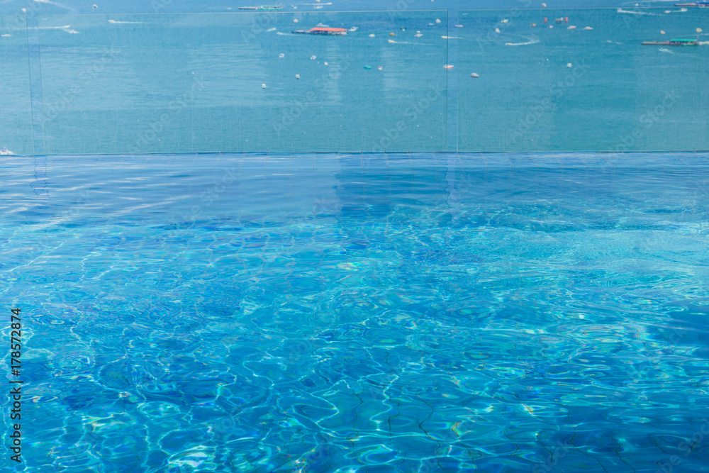swimming pool water surface infinity edge on top of hotel by the sea