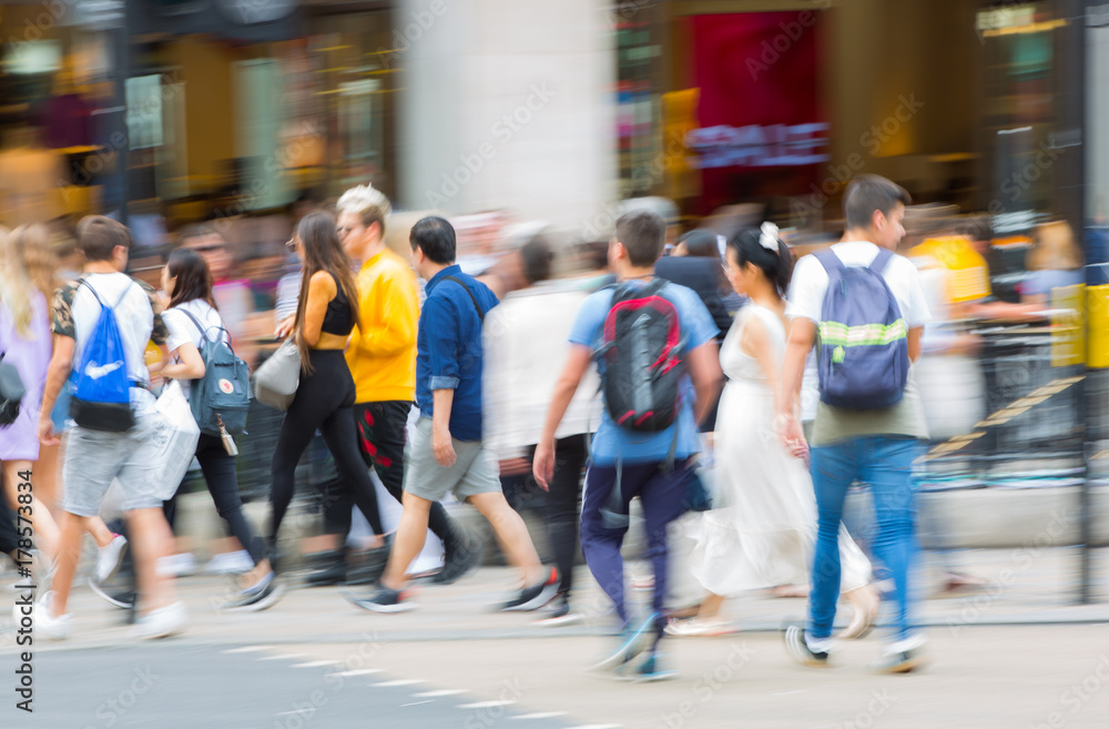 Fototapeta premium Piccadilly circus with lots of people, tourists and Londoners crossing the junction. Red bus at the background. Blurred type image. London, UK