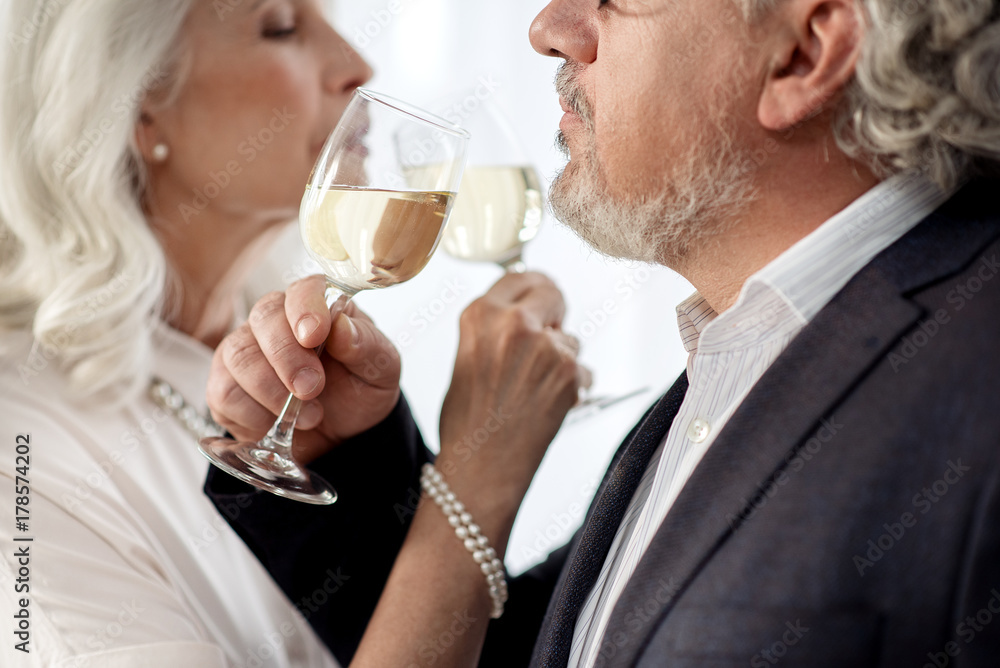 Affectionate mature man and woman enjoying alcohol drink together Affectionate mature man and woman enjoying alcohol drink together