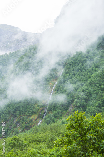 waterfall in mountains foggy day, Norway.