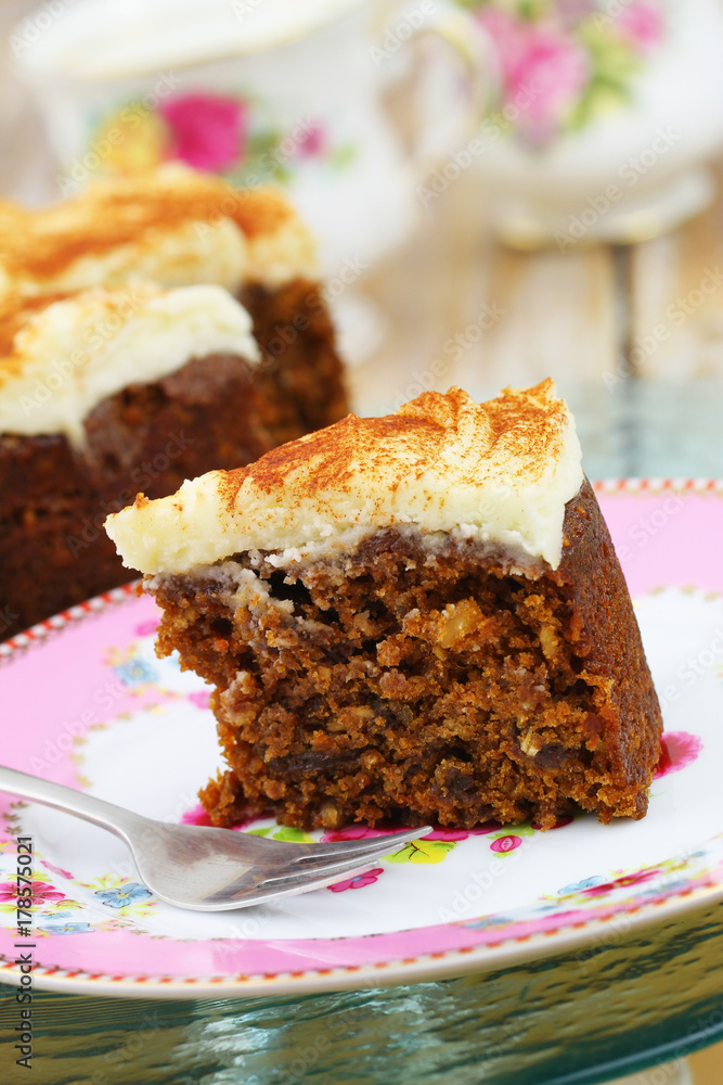 Piece of delicious walnut and carrot cake with marzepain icing on colorful plate
