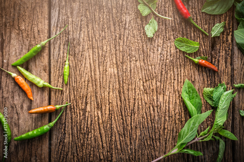 red and green asian chili with basil leaf on wooden table with free copyspace for your ideas text