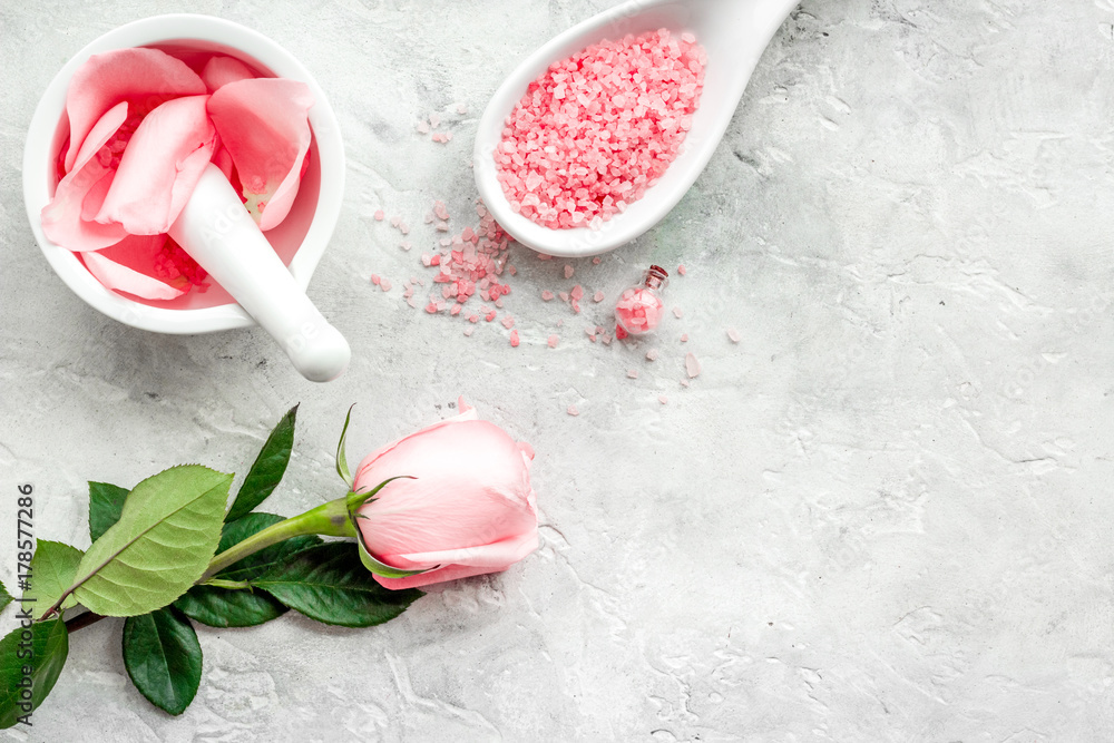 Make cosmetics with rose oil. Mortar with rose petals and pestle on grey stone background top view copyspace Make cosmetics with rose oil. Mortar with rose petals and pestle on grey stone background top view copyspace
