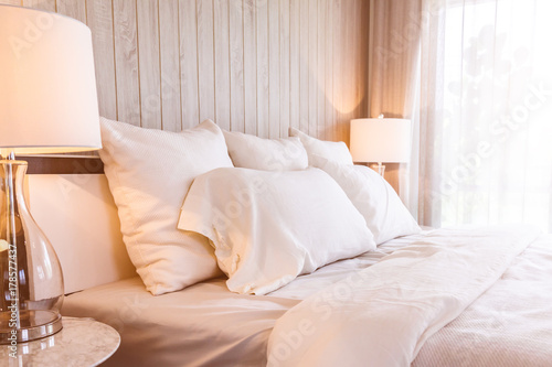 Bed maid-up with clean white pillows and bed sheets in beauty room. Close-up. Lens flair in sunlight. © whyframeshot