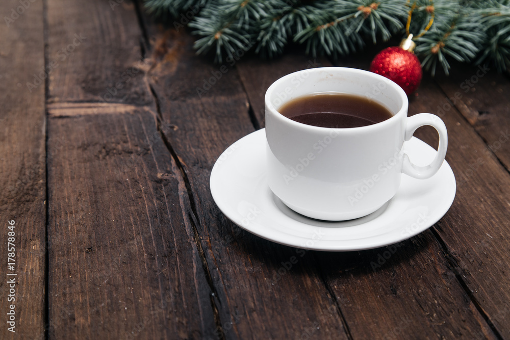 Christmas background with a cup of coffee on wood and xmas tree. Traditional festive Christmas dark background top view. Toned Vintage Effect. Christmas background with a cup of coffee on wood and xmas tree. Traditional festive Christmas dark background top view. Toned Vintage Effect.