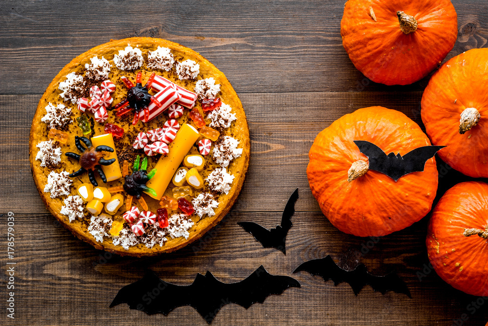 Halloween tradition. Pumpkin pie and bats on wooden background top view