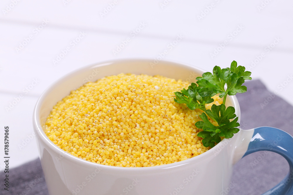 mug of raw millet grains
