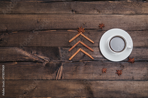 Christmas background with a cup of coffee on wood and xmas tree. Traditional festive Christmas dark background top view. Toned Vintage Effect.