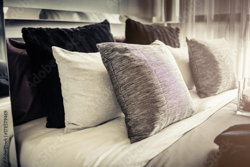 Bed maid-up with clean white pillows and bed sheets in beauty room. Close-up. Lens flair in sunlight.