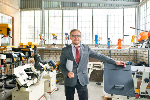 Wallpaper Mural Portrait of successful shop assistant wearing suit posing looking at camera, standing by machine tools in industrial  showroom Torontodigital.ca