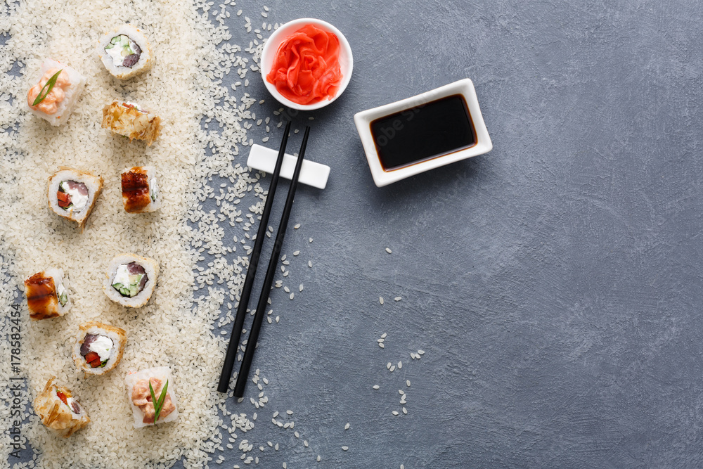 Top view on set of sushi roll, maki on rustic grey and white rice background Top view on set of sushi roll, maki on rustic grey and white rice background