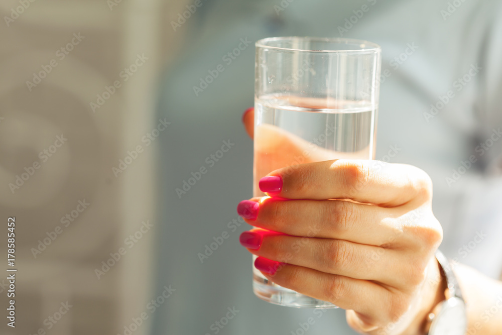 Woman holding a glass of water, close-up Woman holding a glass of water, close-up