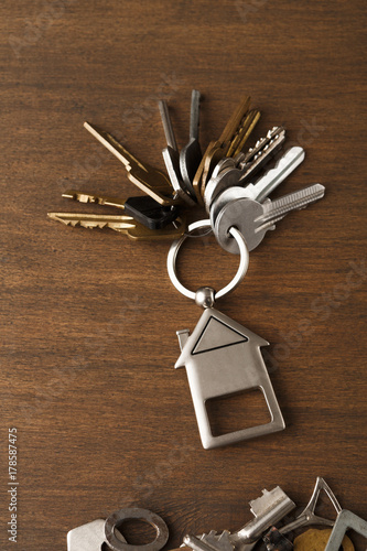 Bunch of keys with house trinklet on wooden table photo