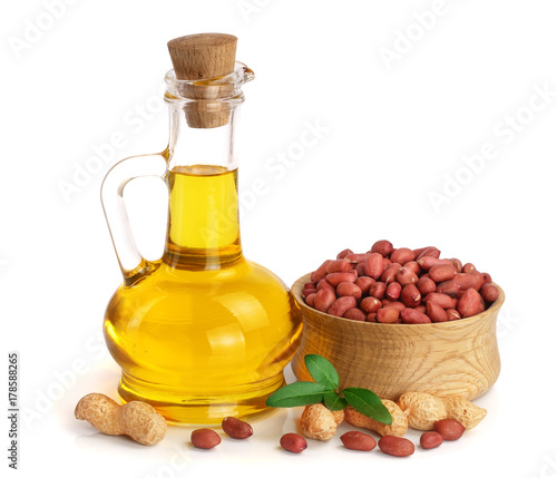 фотографія peanut oil in a glass bottle with peanuts in bowl