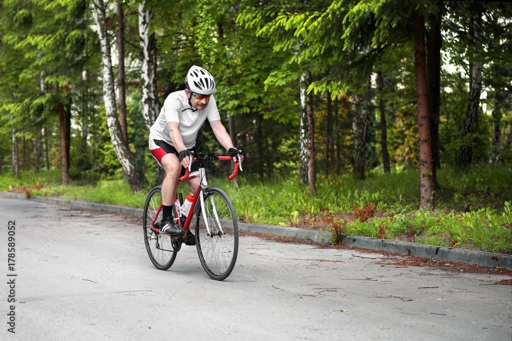 Cyclist riding a road bike in the forest. Cyclist riding a road bike in the forest.