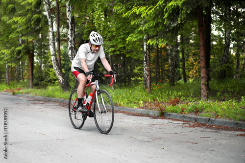 Cyclist riding a road bike in the forest.