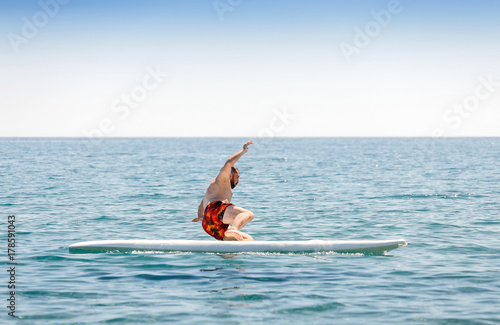 novice surfer beginner falls from the board during training in the sea