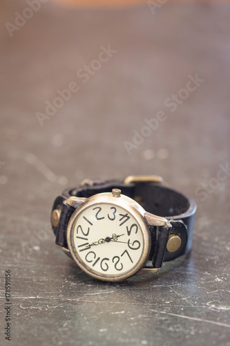 Old wrist watch on black stone table