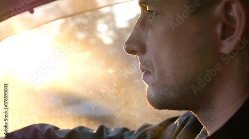 The driver driving the car rides along the road, the bright rays of the sun shine with the effect of the lens. HD, 1920x1080. slow motion.