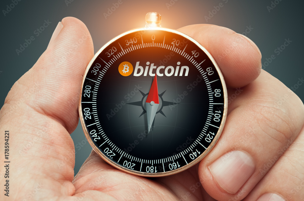 hand holding compass and needle pointing bitcoin logo hand holding compass and needle pointing bitcoin logo