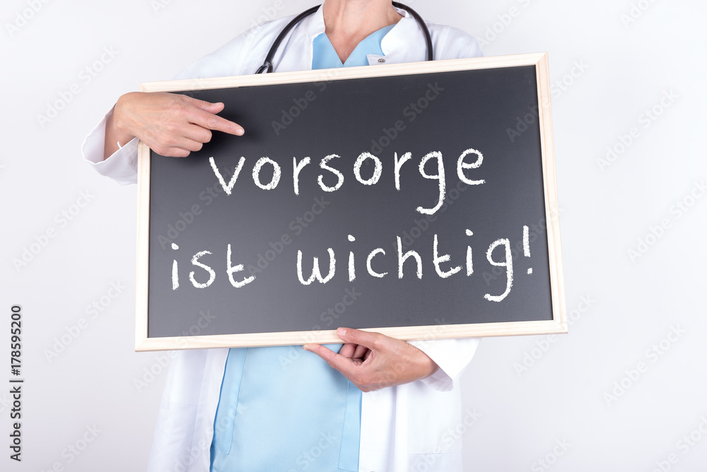 Arzt mit Schild Vorsorge ist wichtig Arzt mit Schild Vorsorge ist wichtig