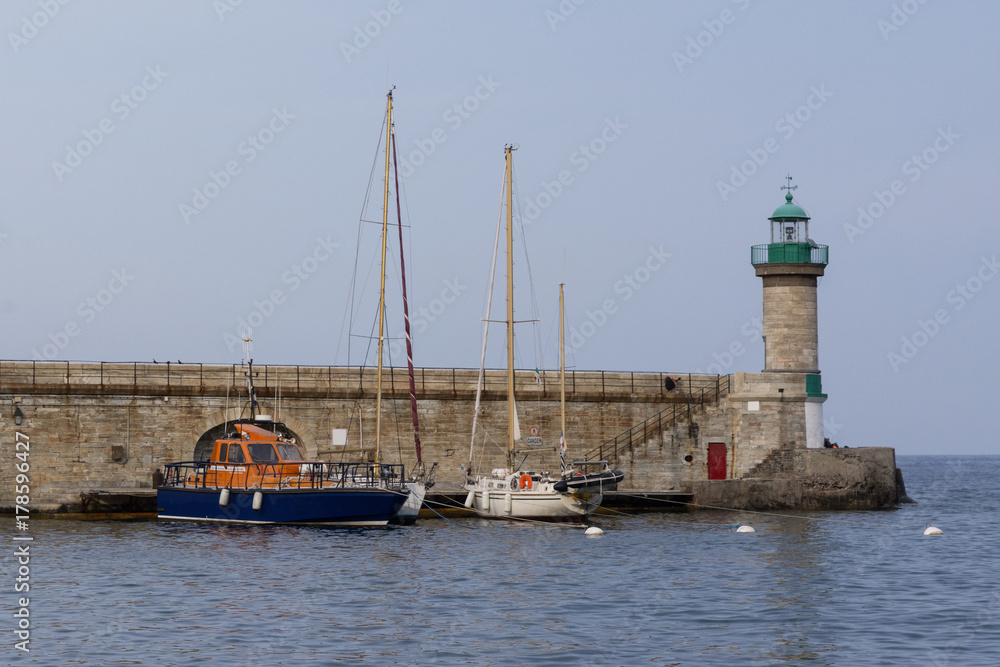 boats moored in front of the lighthouse