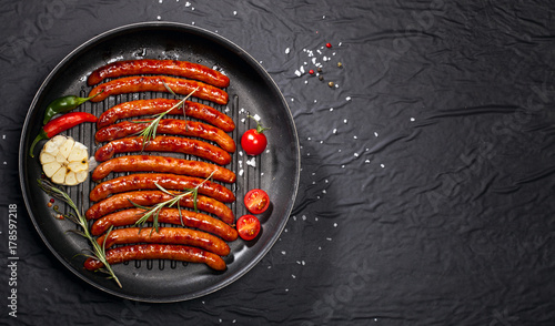 Fotografi Wiener Sausages in a pan on black background with copy space