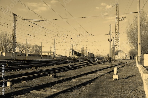 Railway station on the background of blue sky at sunrise with motion blur effect in vintage style. Railroad in Ukraine.