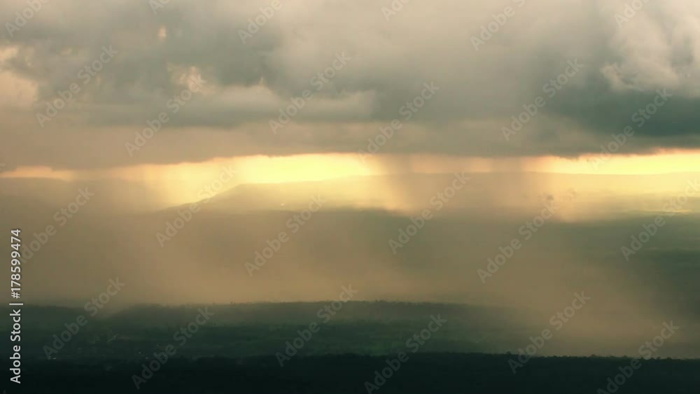 The rain cloud raining over the tropical mountain in sunset time at Phu Hin Rong Kla National Park , Thailand. The rain cloud raining over the tropical mountain in sunset time at Phu Hin Rong Kla National Park , Thailand.