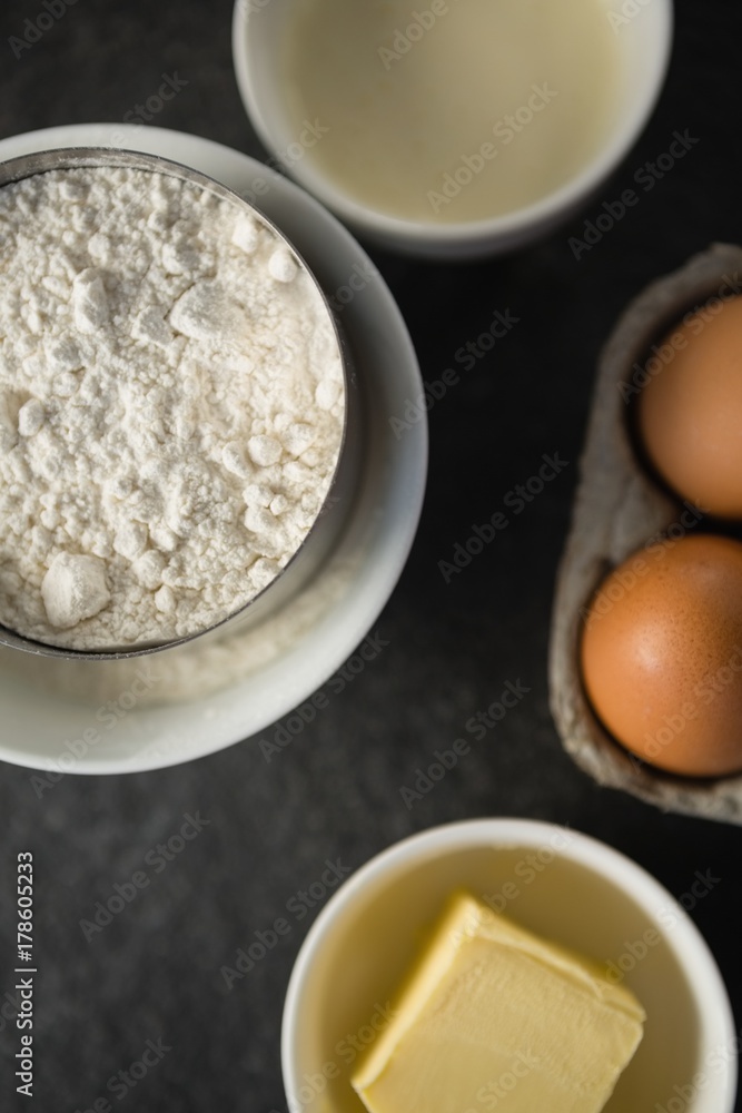 Overhead view of flour with butter and eggs