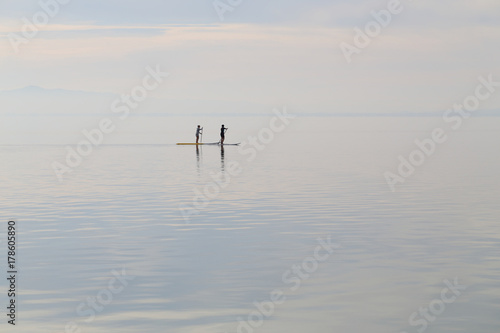 two surfer on the boards on the lake