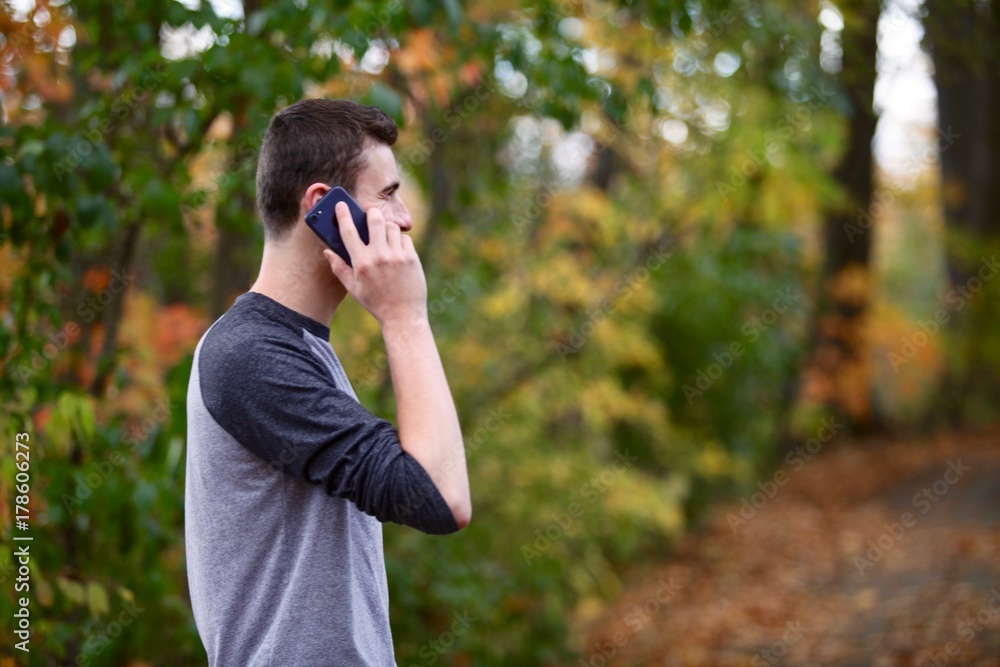 Teenage boy answering a phone call outside Teenage boy answering a phone call outside