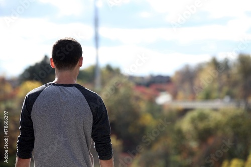 Teenage boy overlooking a view from the top of a mountain