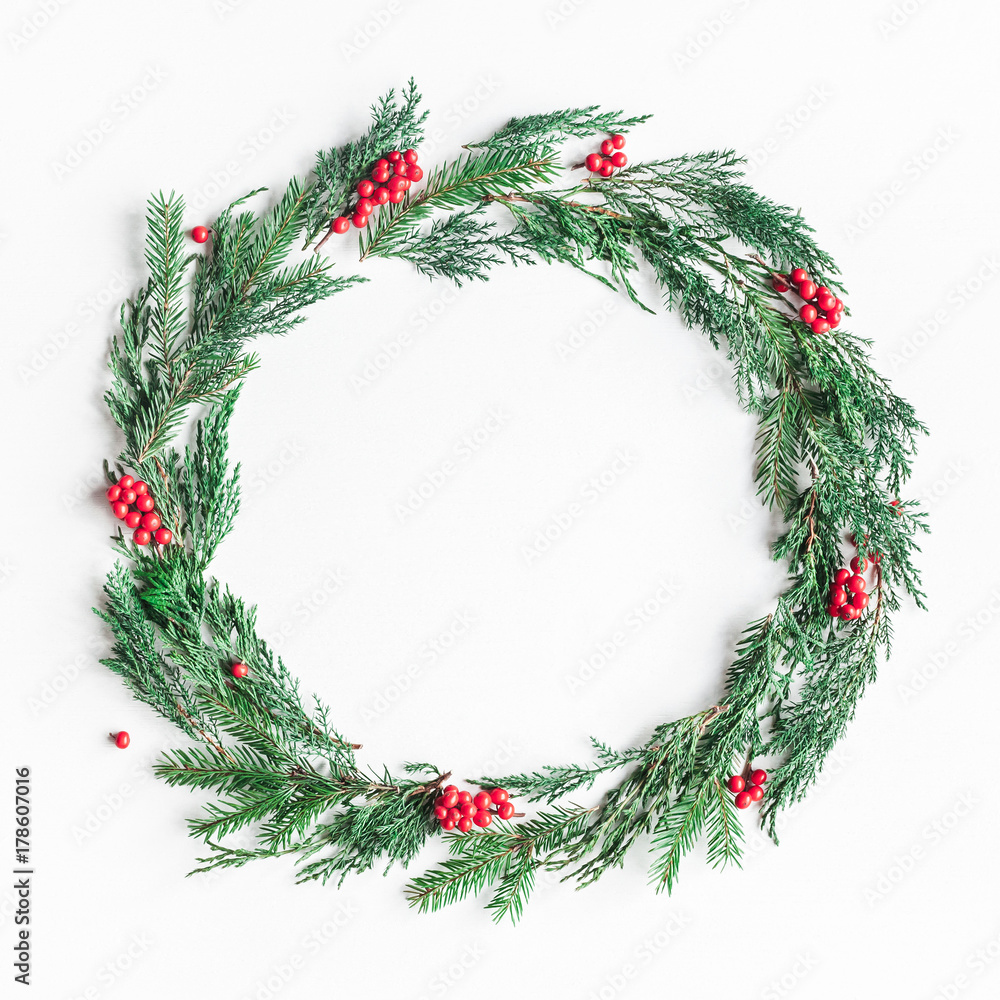 Obraz Christmas composition. Wreath made of christmas tree branches and red berries on white background. Flat lay, top view, copy space, square