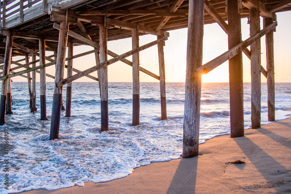 Evening sunset on the wooden structures of a pier. Summer days come to a end on the california coast